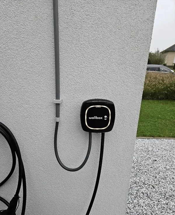 Laadpaal met kabel aan een woning in Jabbeke