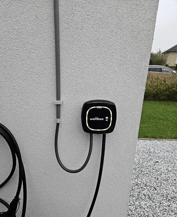 Laadpaal met kabel aan een woning in Jabbeke