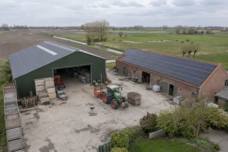 Landbouwbedrijf van bovenaf, met zonnepanelen op de loods en de stal