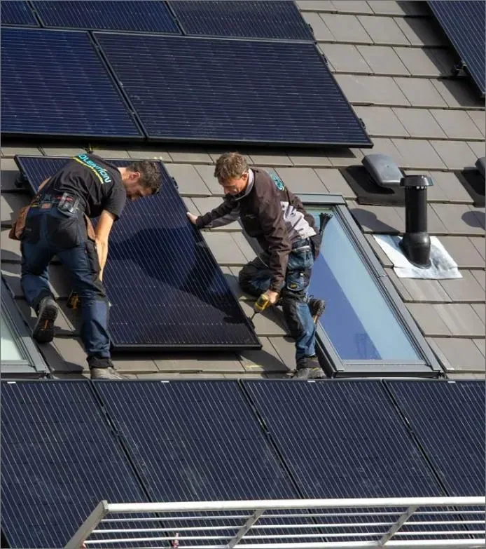 Monteurs van hivolta plaatsen zwarte zonnepanelen rond dakramen